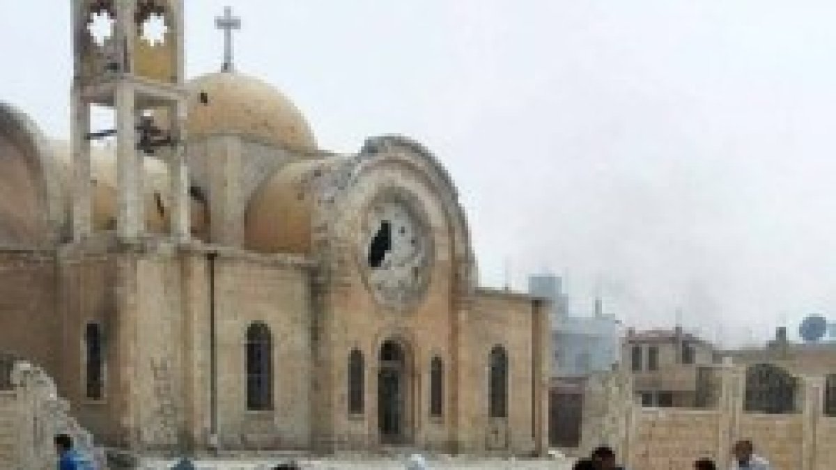 Cristianos greco-ortodoxos se acercan a lo que queda de su parroquia de San Elías en Qusayr, Homs