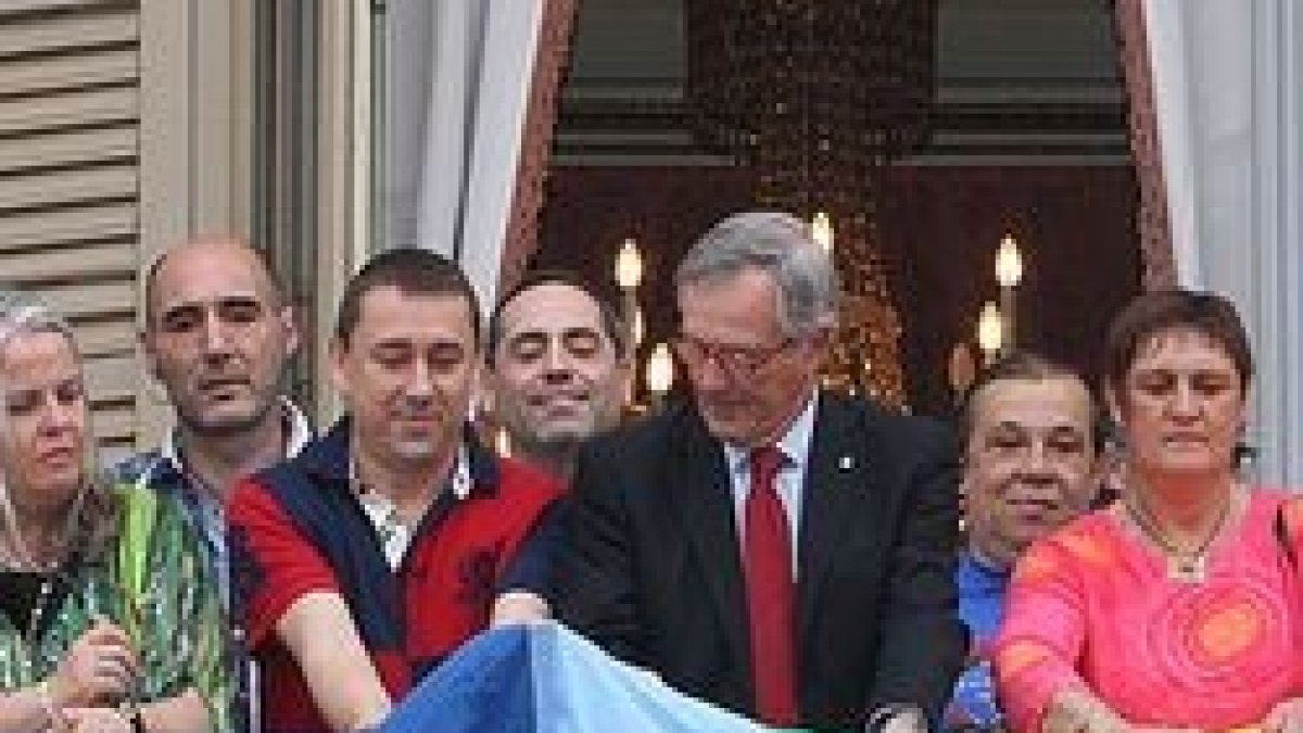 El alcalde de Barcelona, Xavier Trias, de CiU, despliega una bandera gay en el balcón del Ayuntamiento, con líderes del lobby gay de Cataluña