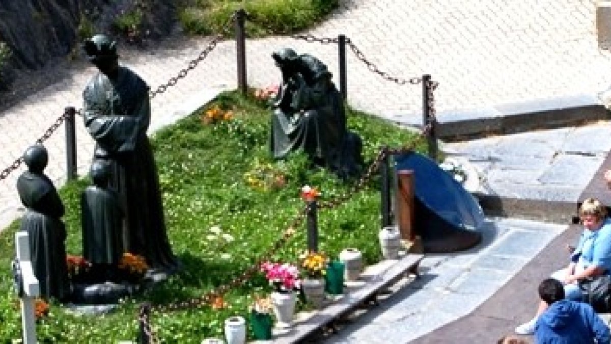 Peregrinos junto a las estatuas que representan a la Bella Señora -de pie y sentada llorando- y los dos pastorcitos videntes