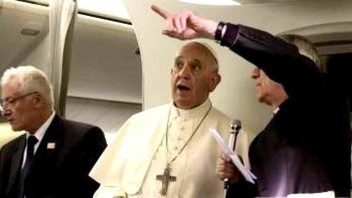 El padre Lombardi ayuda al Papa Francisco con las preguntas de los periodistas en el avión de vuelta de Israel