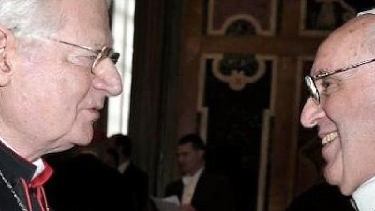 El cardenal Scola conversa con el Papa Francisco.