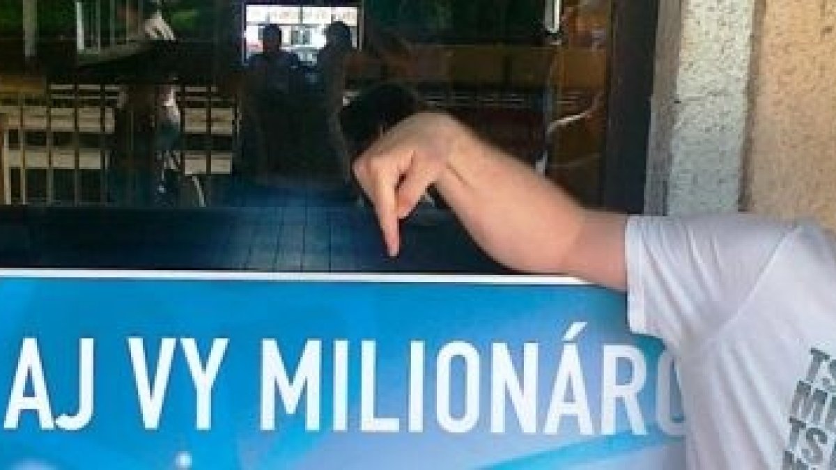 Denis Blaho, hoy profesor de inglés, señala un anuncio de loteria del Euromillón - con la fe, él se sabe ganador