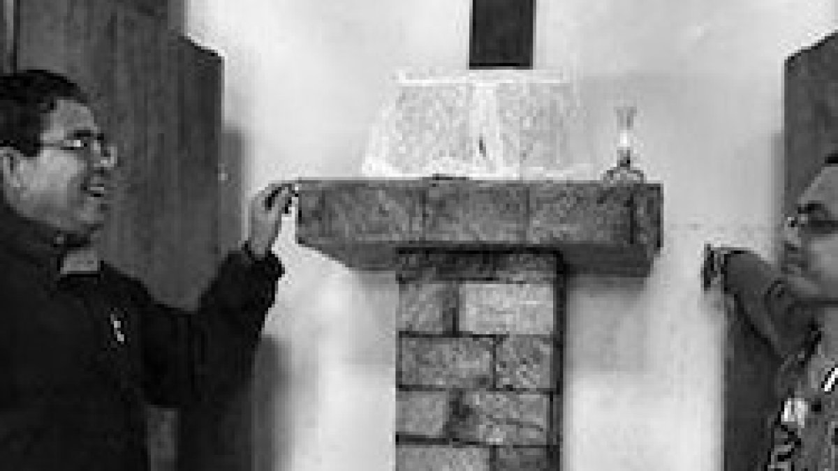 Monseñor Crispin Varquez, a la izquierda, señala el límite alcanzado por la inundación.