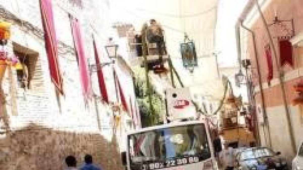 Operarios engalanan las calles de Toledo para el Corpus - unos 100 floristas participan en ello