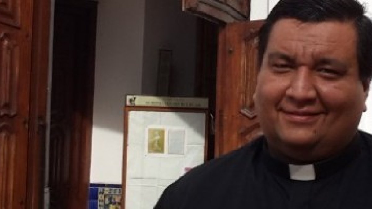 El padre Fabián Báez ante la puerta de su parroquia  - considera Twitter un espacio para estar presente con la gente