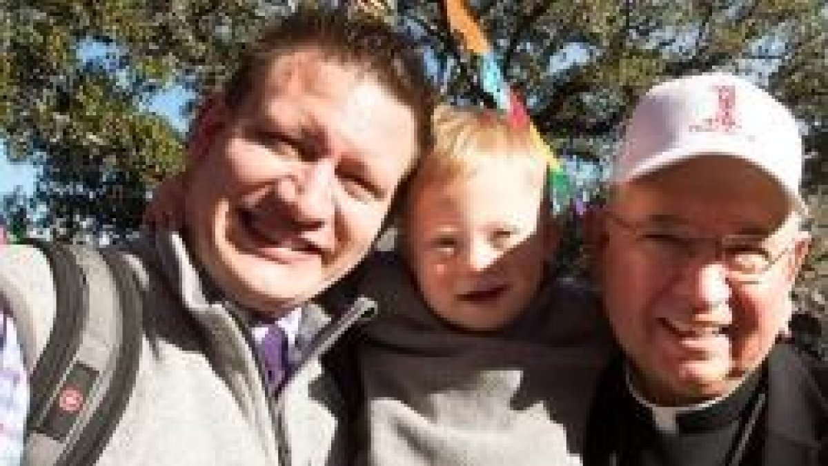 El arzobispo Gómez de Los Ángeles, con la gorra de la Marcha provida y un padre con su joven hijo, manifestantes