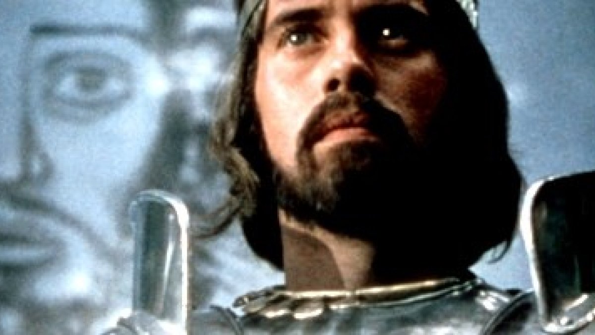 El actor Nigel Terry -recientemente fallecido- interpreta al Rey Arturo en la película Excalibur, con un icono de Cristo tras él