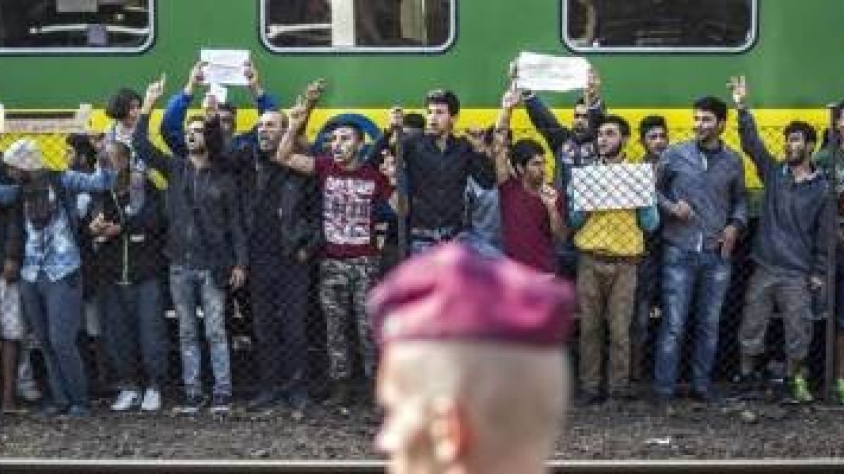 Refugiados de Oriente Medio parados en Hungría protestan ante la policía local