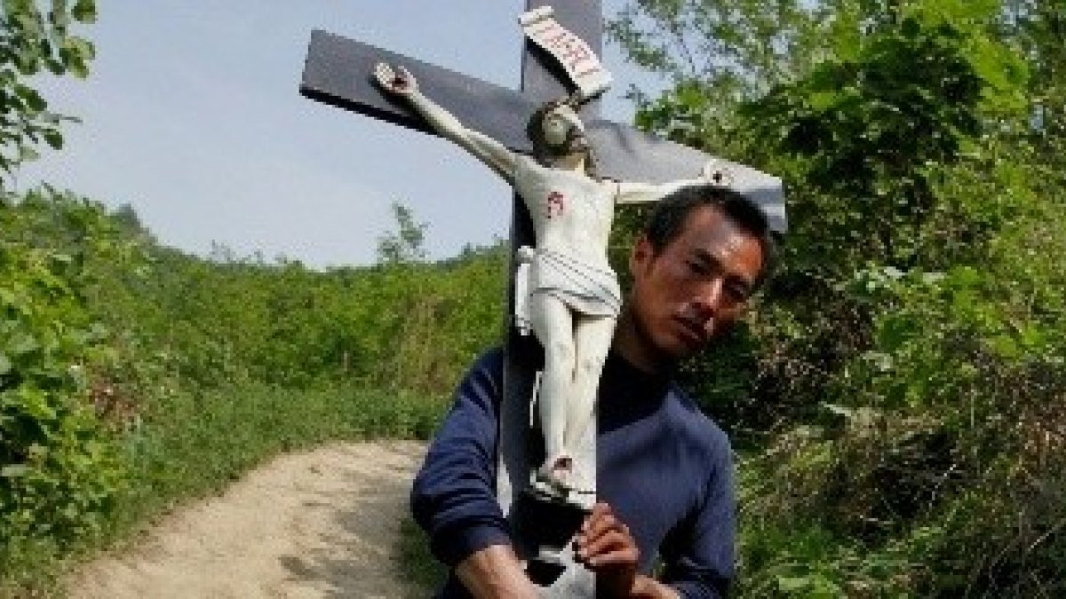 Un peregrino católico con un crucifijo en la provincia china de Shaanxi