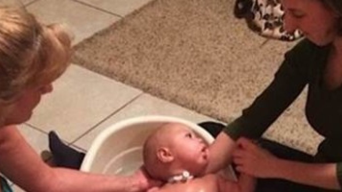 Corie Salchert y su hija de 22 años lavan a Charlie, un bebé que ha estado en reanimación 10 veces en un año