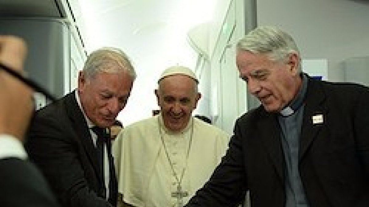 El padre Federico Lombardi (a la derecha) fue homenajeado con una tarta durante el vuelo de regreso de Cracovia, su último servicio como portavoz de la Santa Sede.