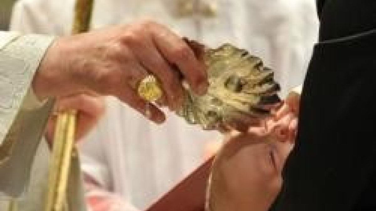 El Papa Francisco -véase el anillo en su mano- bautiza a un pequeño en la Capilla Sixtina