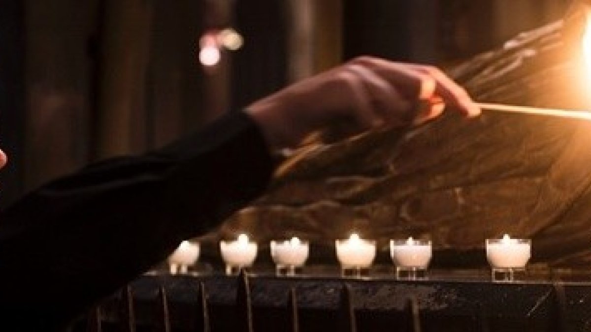 Un joven enciende velas en oración - la paciencia y la oración son las dos armas de quien intenta evangelizar, y más en su familia