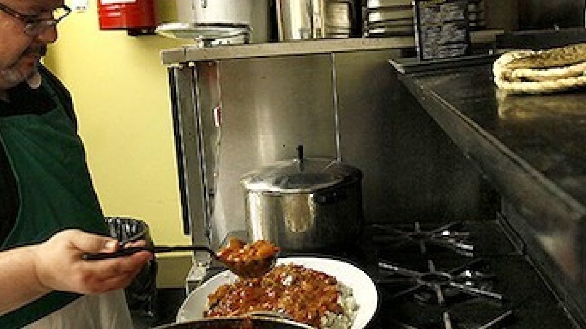 Don David, con el alzacuellos abierto por el calor, trabajando en los fogones de Communio.