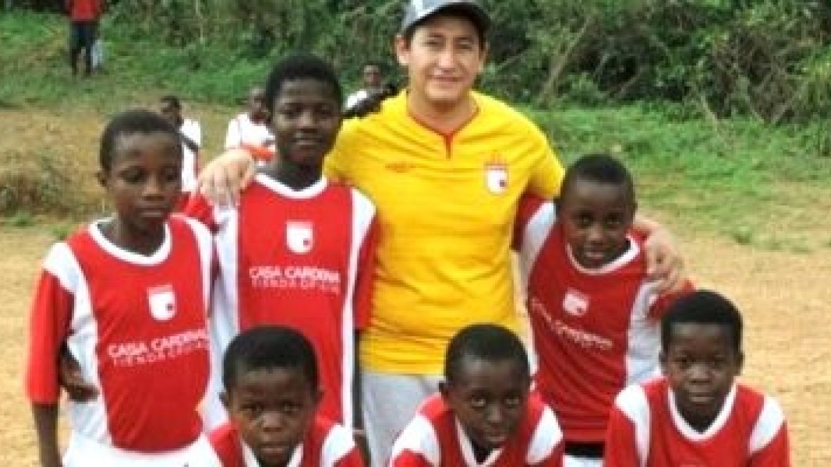 El padre William, en la selva de Camerún, con algunos de los chicos que entrena con camisetas de su equipo colombiano
