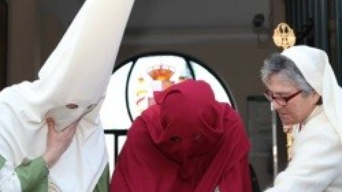 El preso indultado, de rojo, firma su libertad, justo antes de marchar, penitente, con el Cristo del Perdón en Jaén
