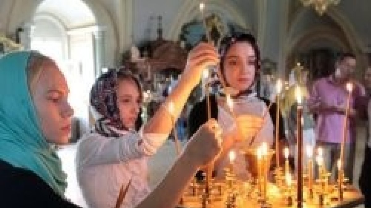 Jóvenes ortodoxas ponen velas en su iglesia - un 30 por ciento de los rusos siente la cercanía de Dios en su vida