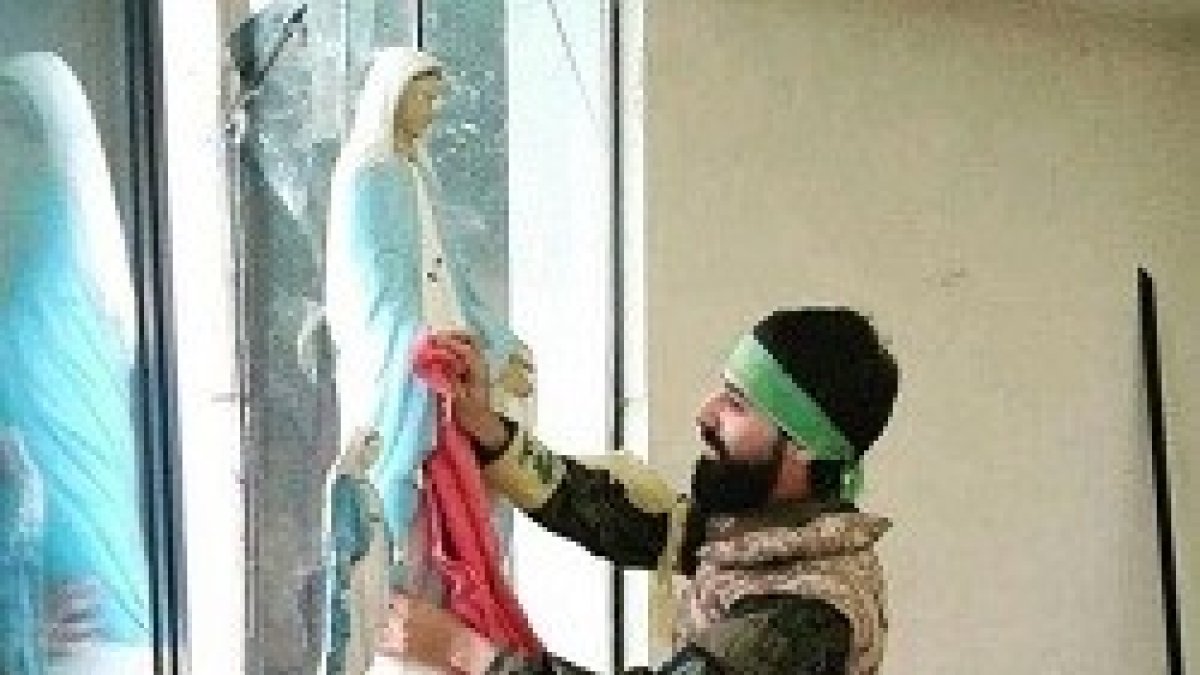 Un combatiente limpia una imagen de la Virgen tras tomar Qaraqosh