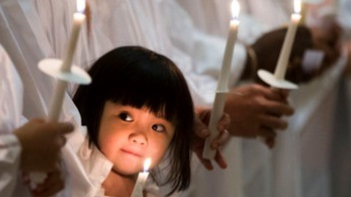 Catecúmenos de blanco dispuestos para ser bautizados en la noche de Pascua