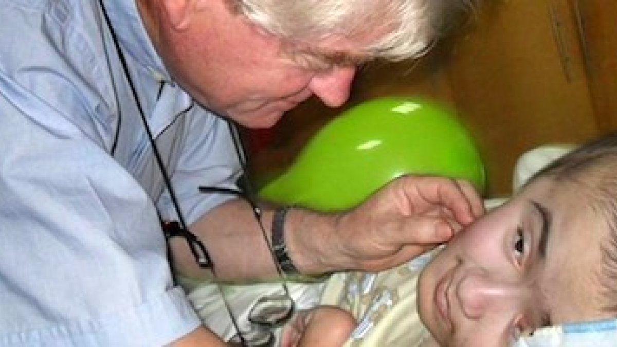 Aldo Trento, junto a un niño con hidrocefalia atendido en uno de sus centros.