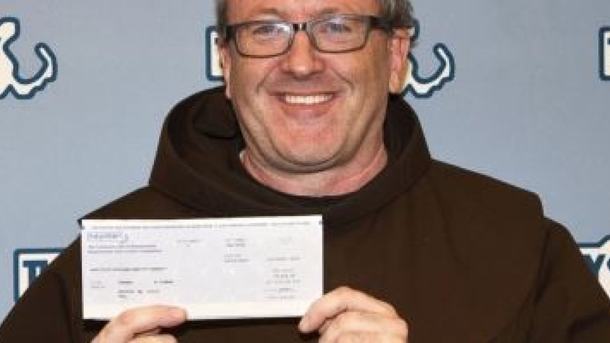 El padre Thomas Conway del santuario de San Antonio de Boston al cobrar el boleto de lotería