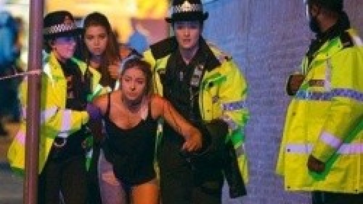 Una chica lesionada en el Manchester Arena, acompañada por policías británicas