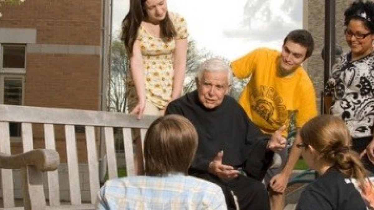 El padre Michael Scanlan, ya mayor, con estudiantes de la Universidad Franciscana de Steubenville