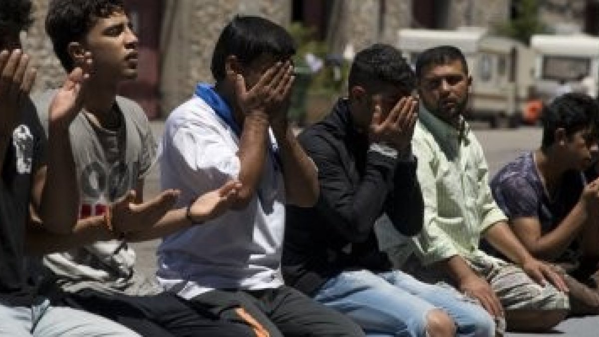 Migrantes musulmanes afganos atascados en Grecia rezar... pero 8 de cada 10 aprueban matar apóstatas y adúlteras.