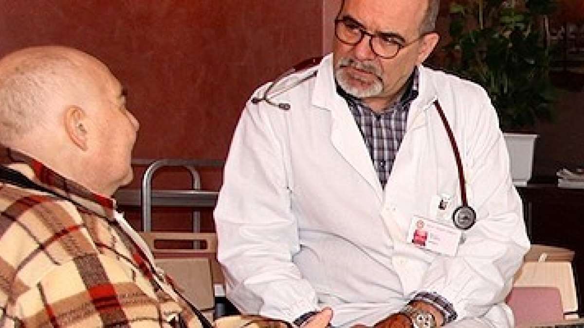 El doctor Claudio Bulla, con un paciente. Este experto en cuidados paliativos advierte contra el uso de la sedación como eutanasia encubierta.