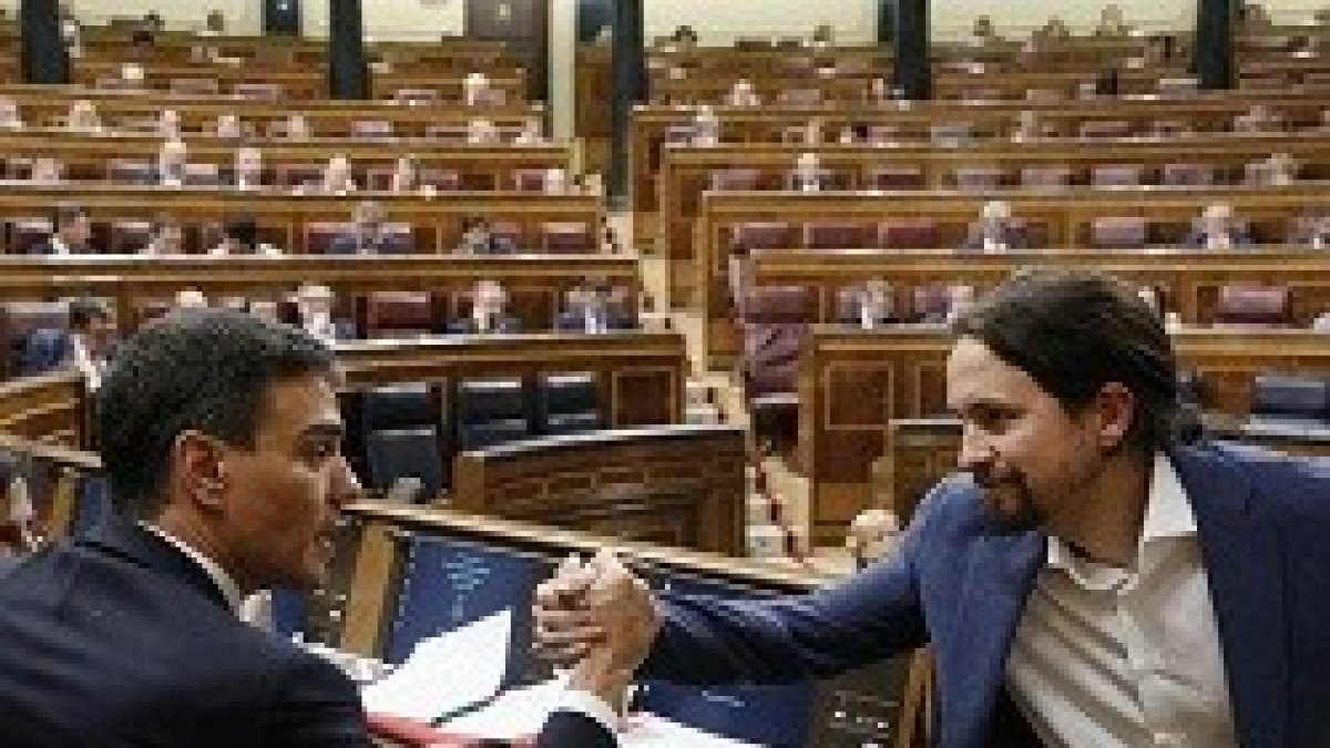 Pablo Iglesias (Podemos) saluda a Pedro Sánchez (PSOE), nuevo presidente del Gobierno