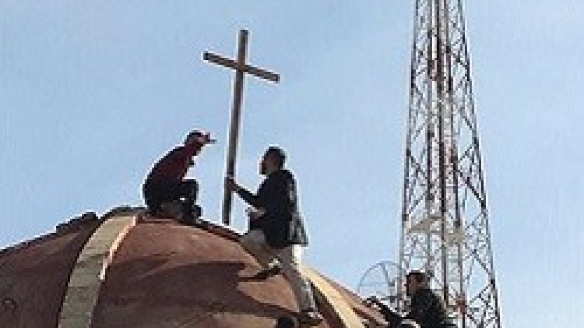 Varios cristianos vuelven a colocar la cruz en la cúpula de la iglesia