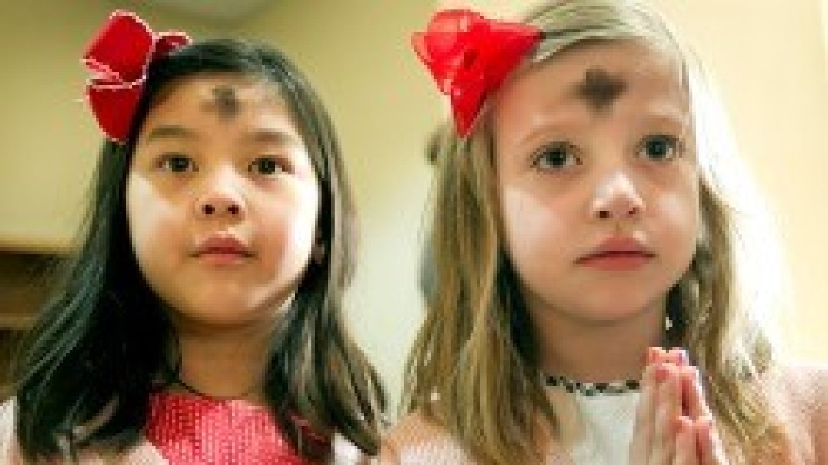 Unas niñas en Miércoles de Ceniza, con el signo que marca el inicio de Cuaresma