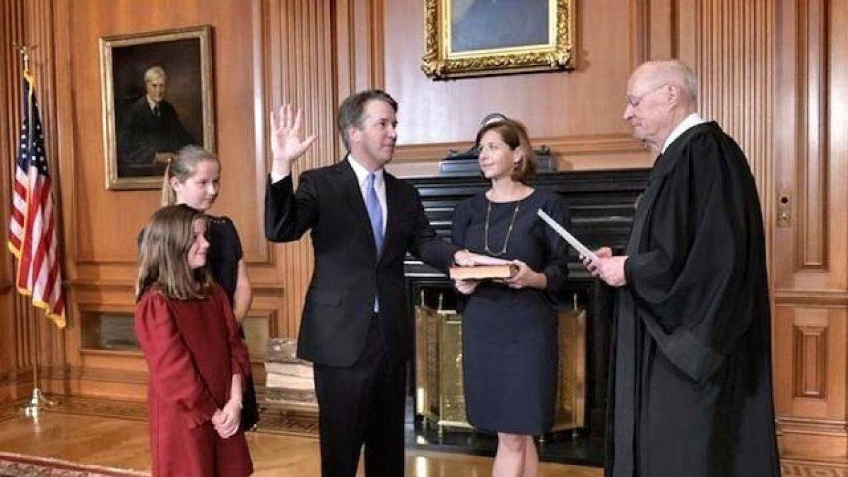 Brett Kavanaugh jura como miembro del Tribunal Supremo ante el juez al que sustituye, Anthony Kennedy, mientras su esposa Ashley sostiene la Biblia. Foto: AP.