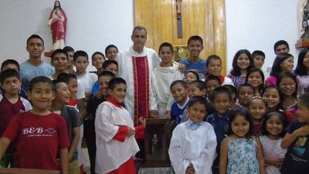 El padre Ignacio María Doñoro con niños del Hogar Nazaret tras recibir la capilla peregrina del Padre Pío llegada desde España