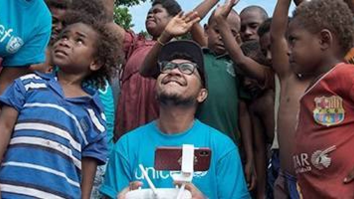 Un técnico de Unicef prueba unos drones rodeado de niños de Vanuatu - un país con 80 islas al sur del Océano Pacífico