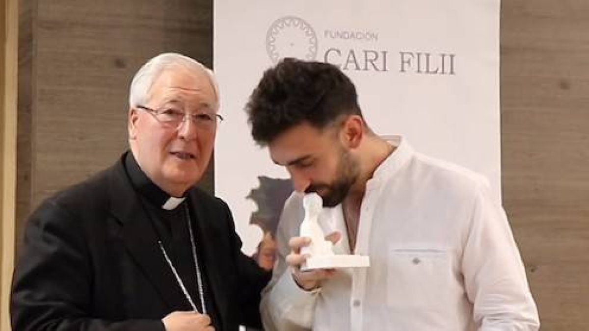 Uno de los ganadores besa la imagen de la Virgen que monseñor Reig Pla entregó a los premiados junto con el diploma acreditativo.