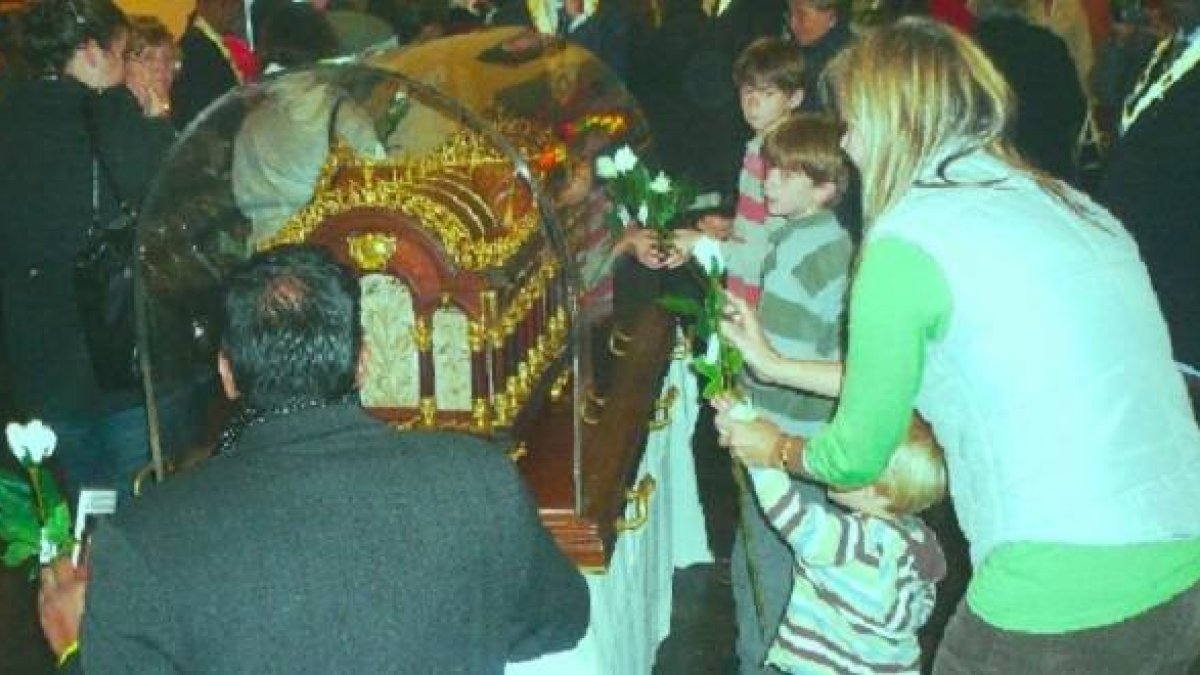 La familia Paulson, con Kate y sus tres hijos, venerando las reliquias de Santa Teresita.