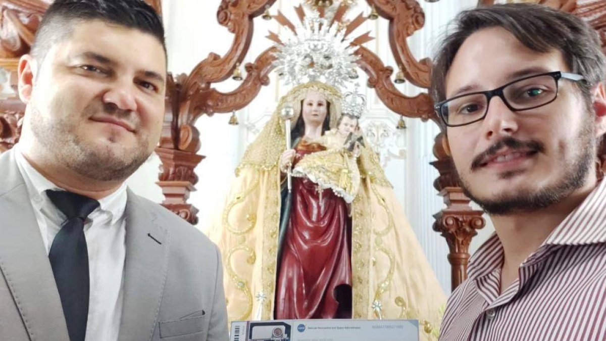 El militar entusiasta y el Hermano Mayor de la cofradía de la Virgen de Flores, en Álora, con su billete para Marte