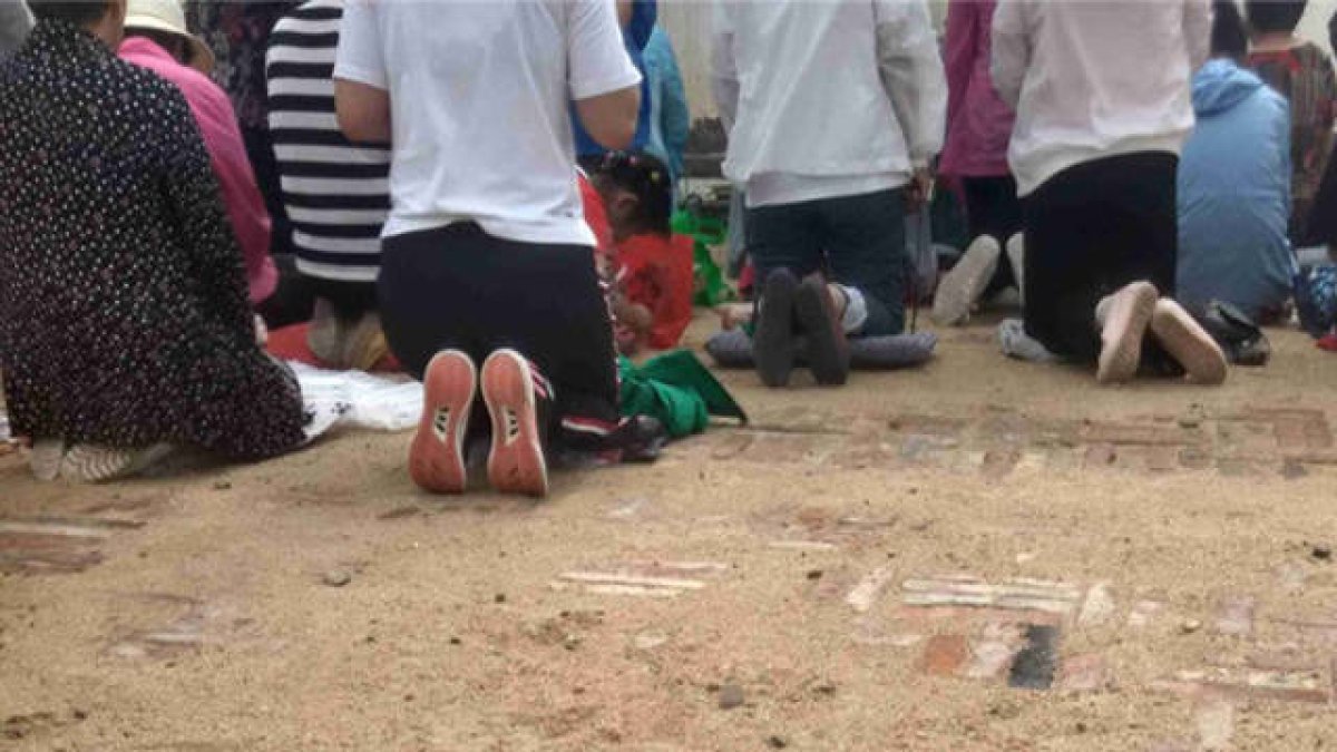 Los creyentes están celebrando una reunión en el patio de la iglesia tras su expulsión del templo