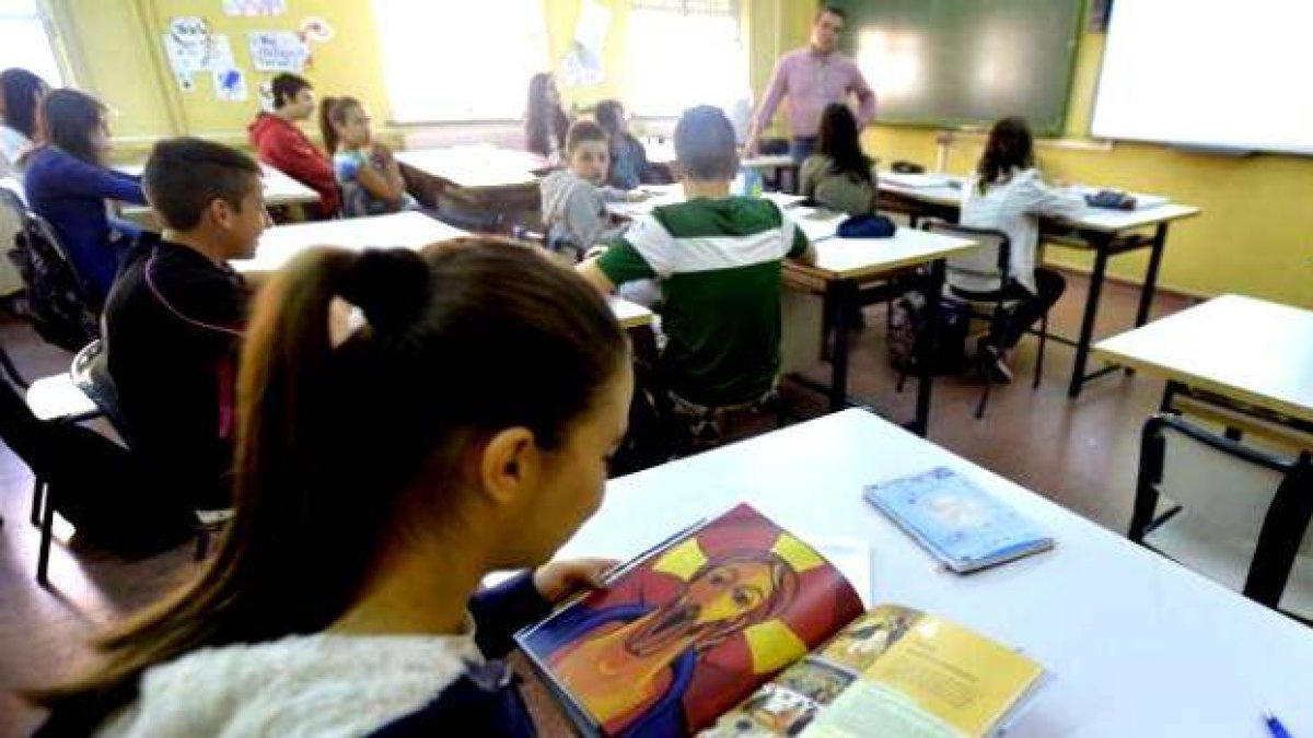 Una alumna hojea el libro de la asignatura de religión... los gobiernos de izquierda en España intentan reducirla al máximo