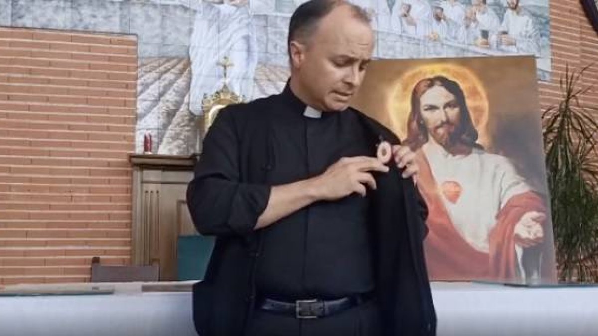 El padre Arellano muestra el Detente que lleva puesto, un arma para luchar contra el coronavirus