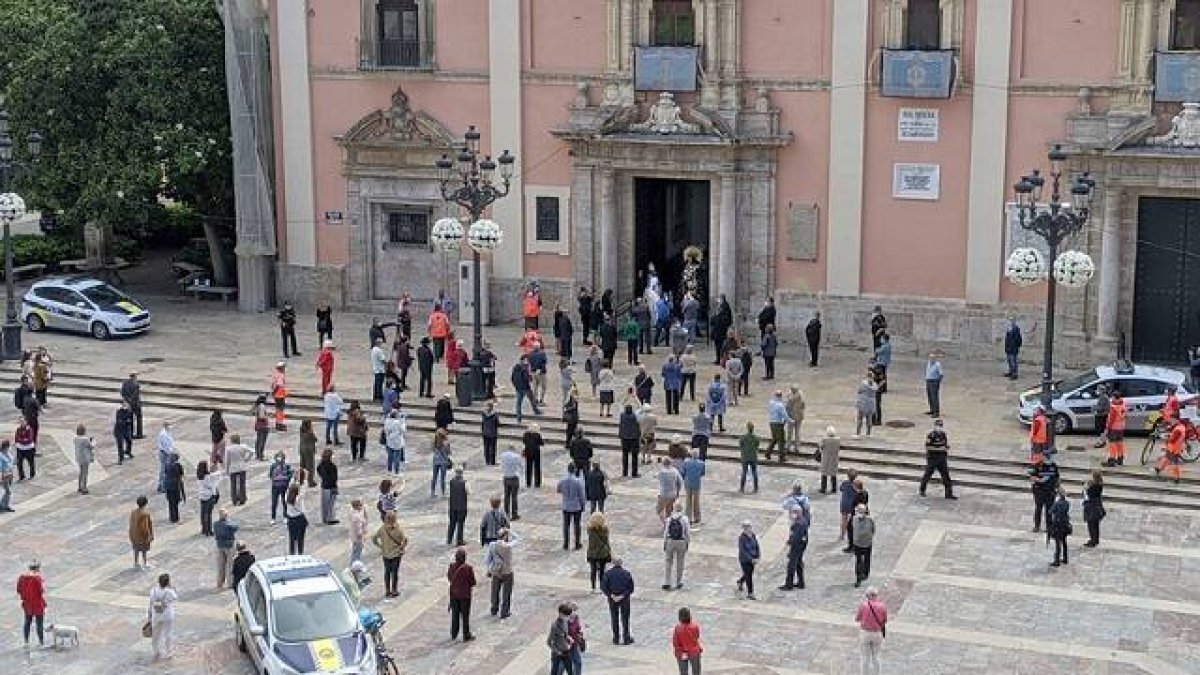 Imagen de la basílica con la imagen a las puertas de la basílica. Las personas que se pararon a observar a la Virgen guardaron la distancia