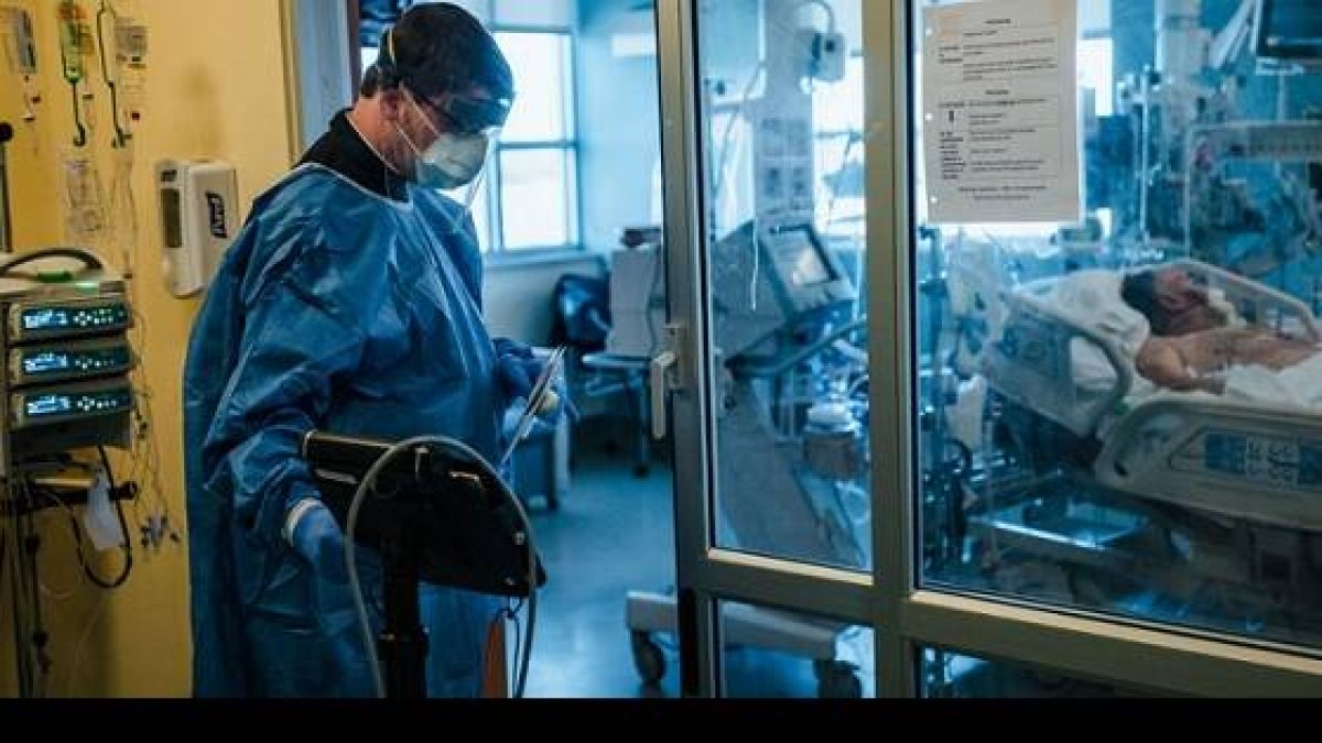 El padre Connors se prepara para administrar la extrema unción a un paciente sedado y entubado - Fotos del reportaje del The New York Times