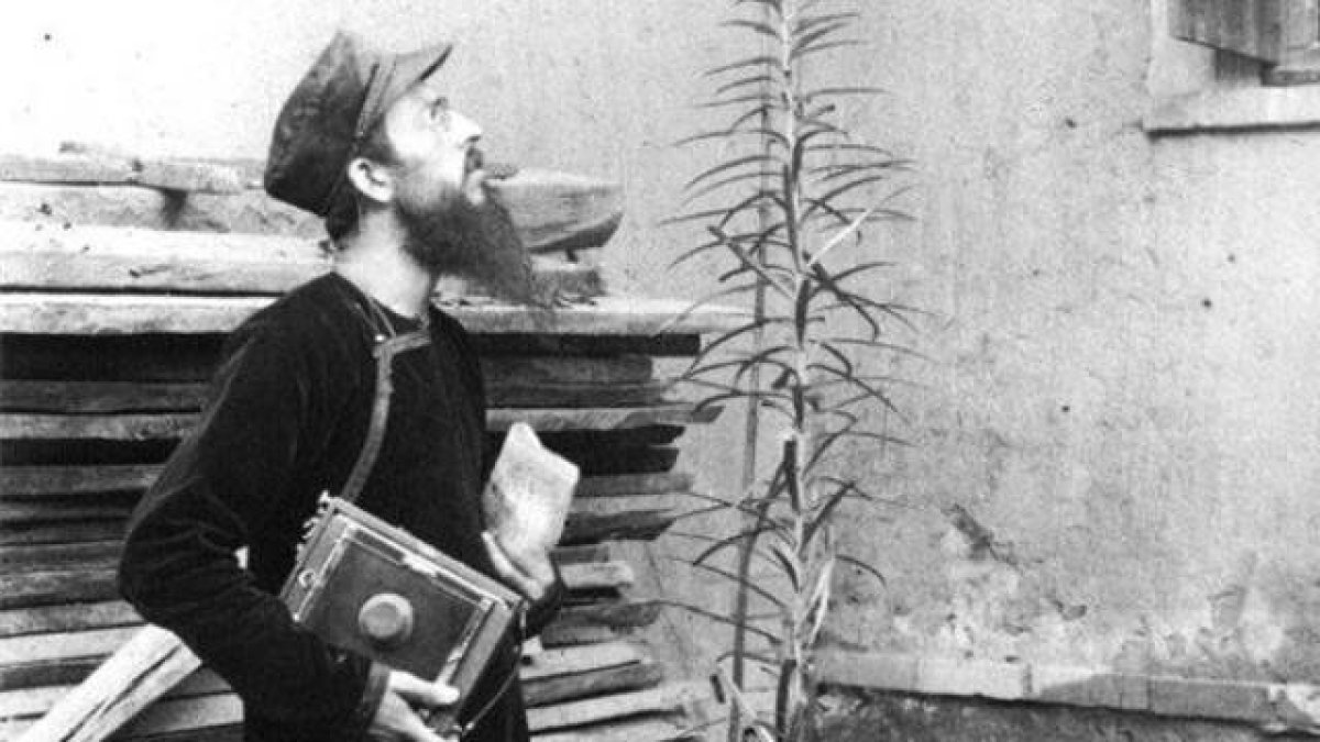 El misionero Leone Nani, con su cámara, asombrado ante una flor... quizá un símbolo de las misiones