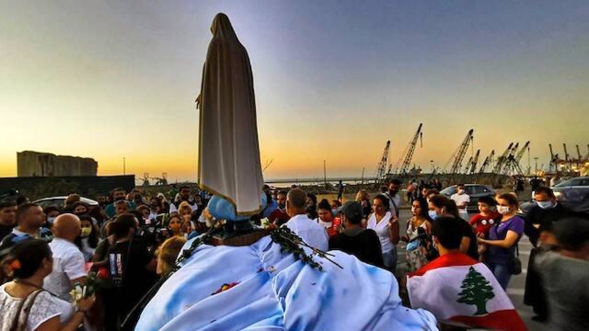 Un grupo de libaneses rezan a la Virgen en la festividad de la Asunción, en el puerto de Beirut, cerca del lugar de la explosión. Foto: Thaier Al-Sudani / Reuters.