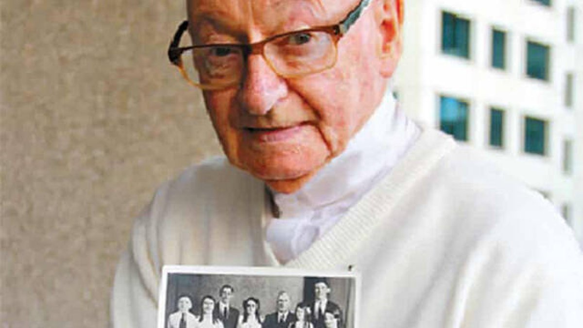 El P. William Creede con una foto de su familia