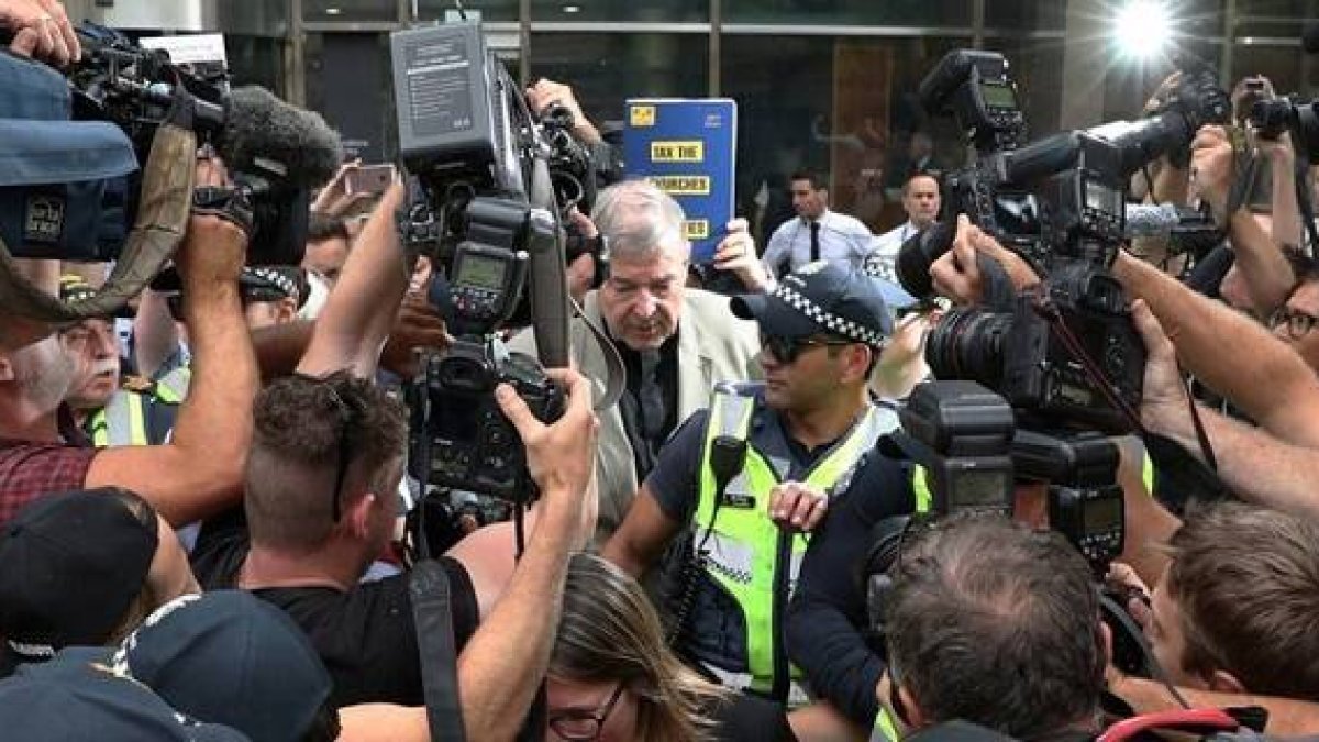 El cardenal Pell cuando llegaba a los juzgados y la prensa le atosigaba... el sistema legal australiano intenta evitar juicios paralelos en los medios