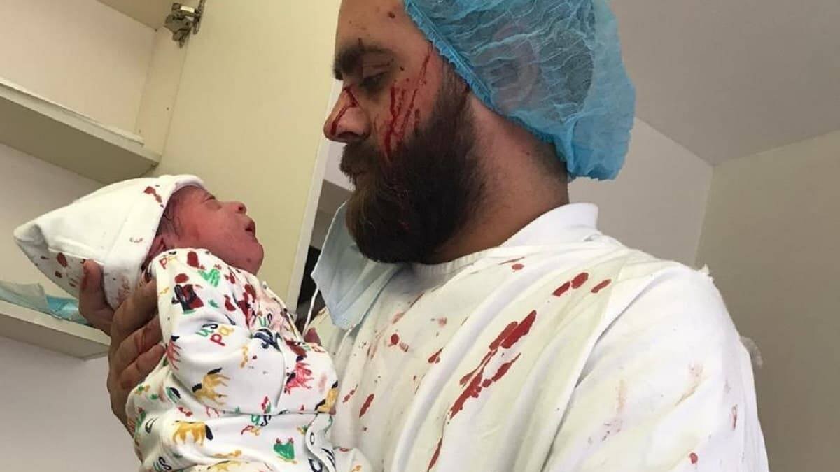 Jad, lleno de sangre debido a los efectos de la explosión, sujeta a su hijo Nabil, que no sufrió ni un rasguño / Fotos- ACN