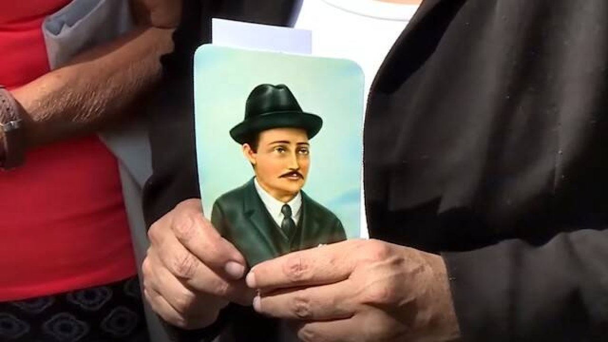 Una mujer sostiene una estampa del doctor José Gregorio Hernández celebrando su beatificación.