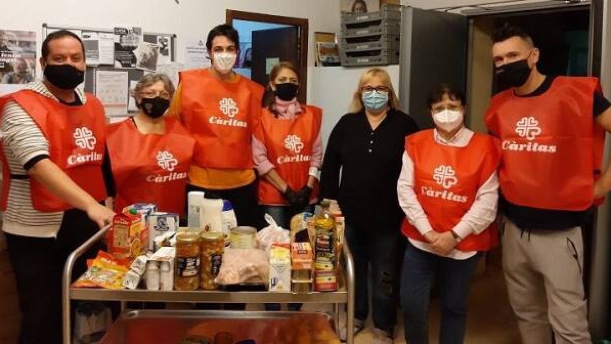 Voluntarios de Cáritas en la parroquia de Santa Tecla de Barcelona, con sus mascarillas contra el coronavirus